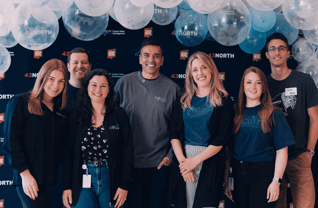 Group of people smiling with balloons in the background